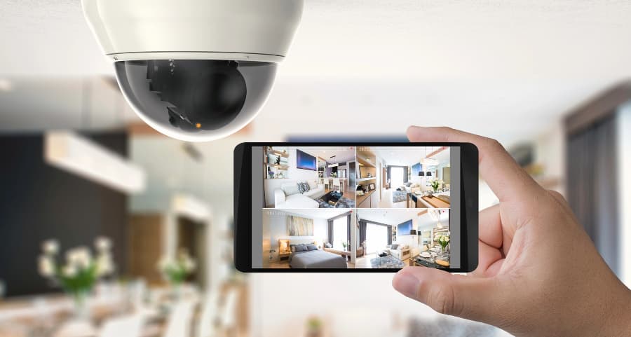 Homeowner holding smartphone with video feed from security cameras in Palm Springs